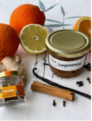 Zutaten für Orangenmarmelade und ein Glas fertige Marmelade